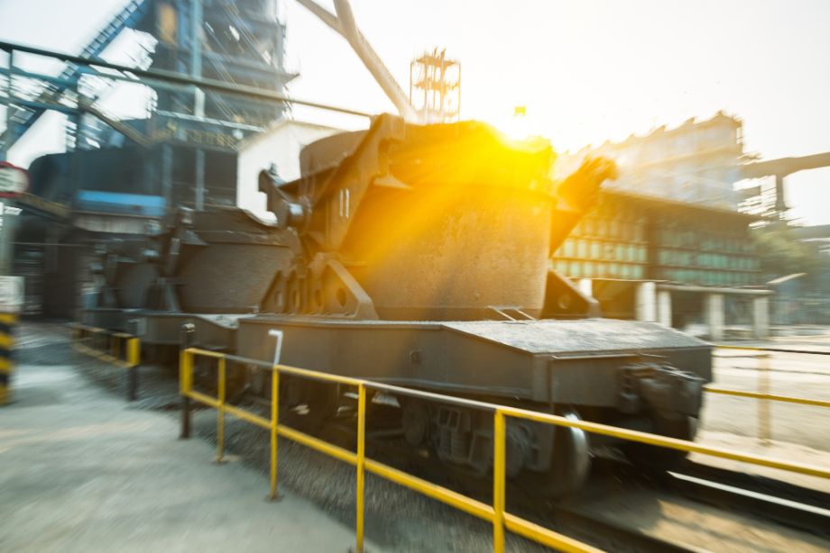 heavy equipment logistics – massive industrial ladle car in steel mill at sunrise