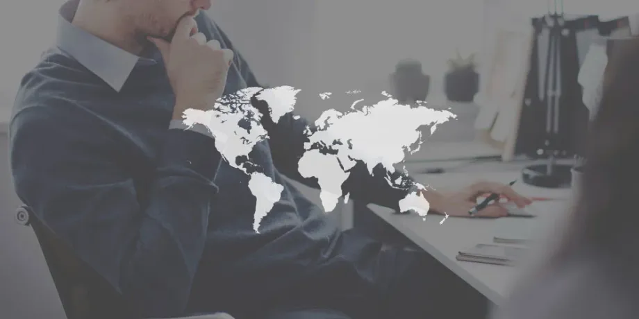 Businessman planning international logistics with global map overlay – representing global freight strategy